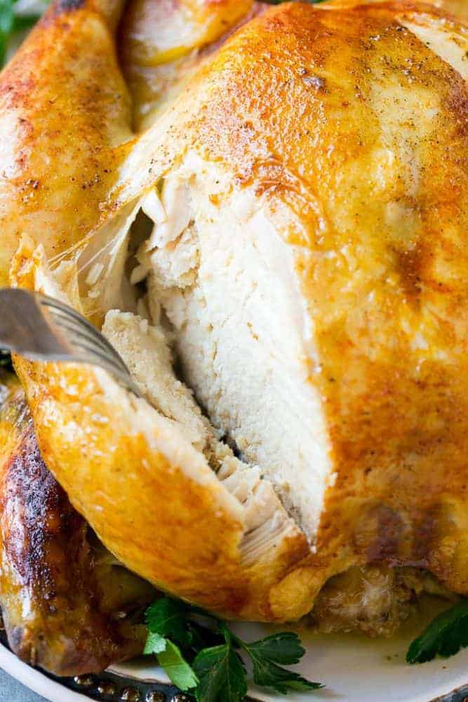 Cooking a whole chicken has never been easier than this Instant Pot roasted chicken! The chicken cooks in just 30 minutes and produces a moist and juicy bird that's the perfect simple dinner option! Sliced Cooked chicken and a fork.