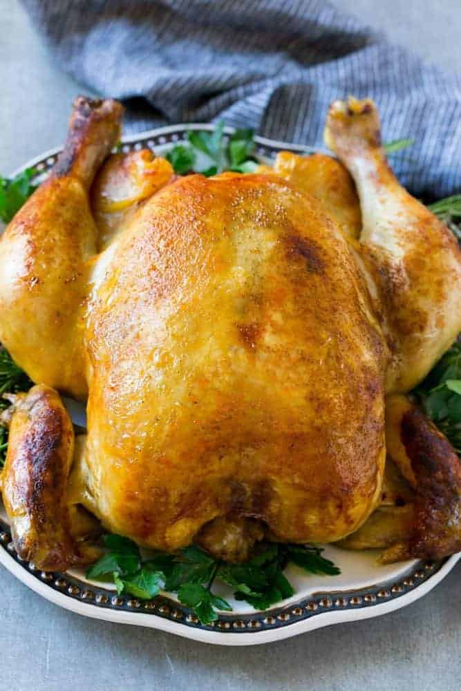 Cooking a whole chicken has never been easier than this Instant Pot roasted chicken! The chicken cooks in just 30 minutes and produces a moist and juicy bird that's the perfect simple dinner option! Entire cooked chicken on a plate.