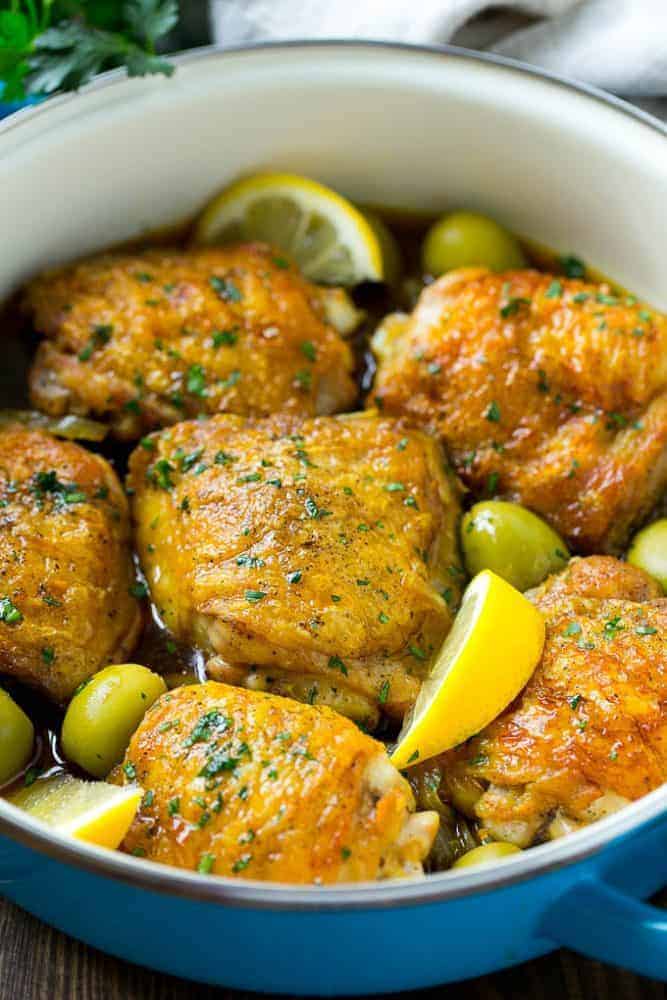This Moroccan chicken is tender chicken thighs cooked in an aromatic sauce with olives and lemon. An easy dinner that's full of unique flavors! This Moroccan chicken in an iron pot.