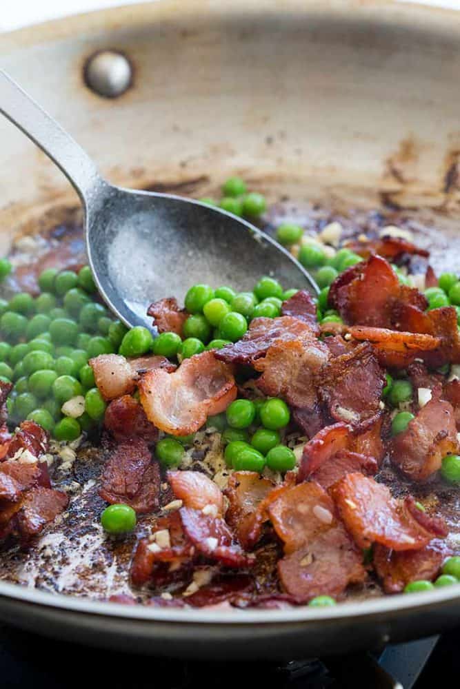 Pasta Carbonara is a favorite Italian dish made with wholesome ingredients. The creamy sauce is made with eggs and Parmesan cheese, using a special technique to ensure a smooth and luscious texture. Spaghetti noodles are topped with chopped bacon and sweet peas for the ultimate comfort food. Sautéing peas and sliced bacon in a frying pan.