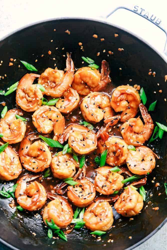 Sticky Sesame Garlic Shrimp is coated in the most amazing sticky Asian sauce and topped with green onions and sesame seeds! This is a quick and easy 30-minute meal that you will make again and again! Sticky Sesame Garlic Shrimp in a skillet.