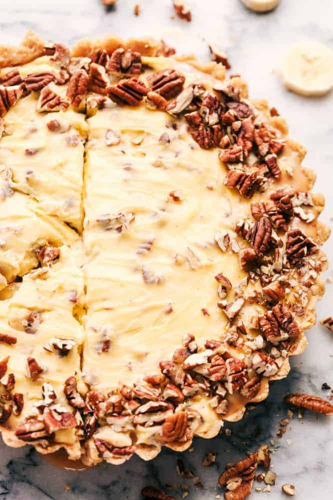 No Bake Banana Caramel Pecan Pie is made with a shortbread crust topped with caramel and a creamy banana filling with crunchy pecans. This makes one incredible no bake pie! No Bake Banana Caramel Pecan Pie that has been sliced.