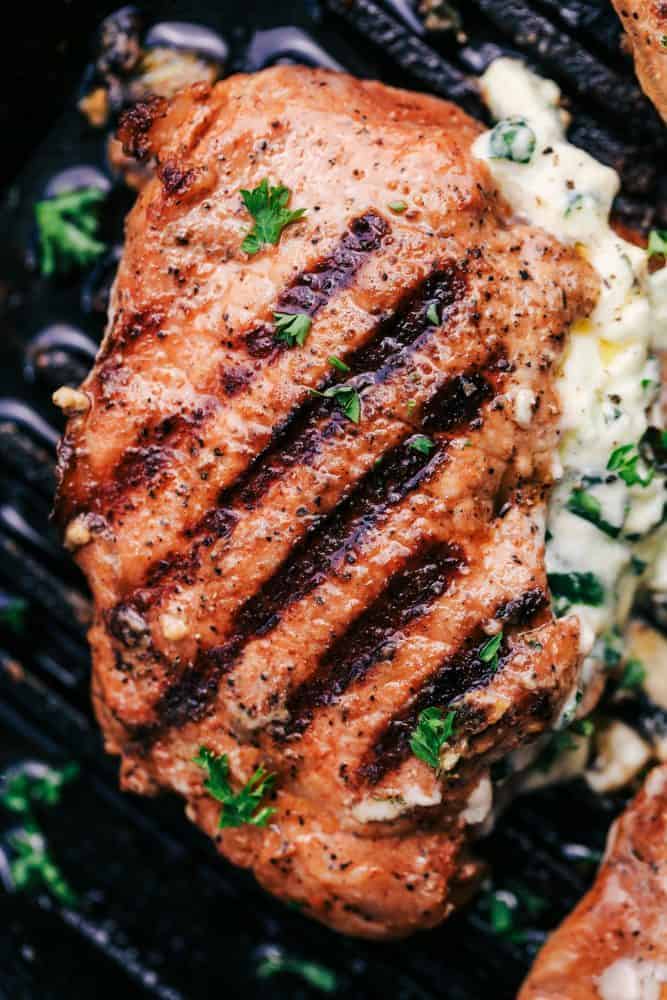Grilled Spinach and Herb Stuffed Pork Chops are so easy to make and stuffed with a creamy parmesan spinach and herb mixture that takes these delicious and full of flavor pork chops to the next level! Close up of Herb Stuffed Pork Chop.