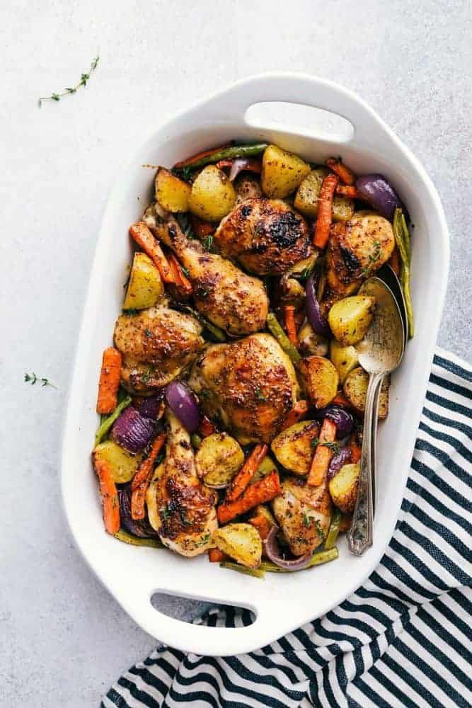 Delicious savory honey mustard chicken and root vegetables all cooked together on ONE sheet pan! Honey mustard chicken and root vegetables in a white serving bowl.