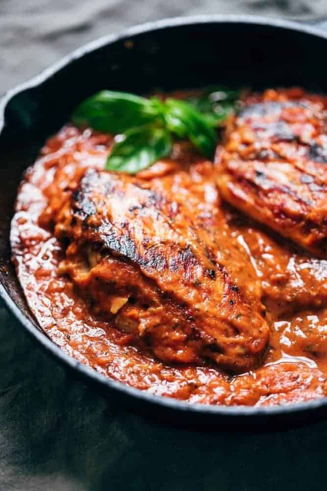 Creamy Tomato Basil Chicken is a simple, one pan meal that the entire family will love. With only five ingredients that are most likely in your pantry, this is an easy recipe that will become a dinner favourite! Creamy tomato basil chicken in a cast iron skillet ready to be served.