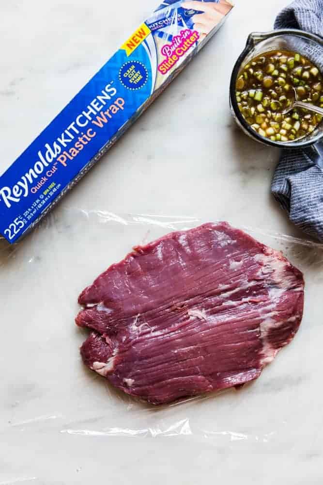 Brown Sugar Garlic Flank Steak is made with the most amazing brown sugar garlic soy marinade. The steak is grilled to perfection and melt in your mouth delicious!ย Un-cooked flank steak on a piece of Reynolds wrap.
