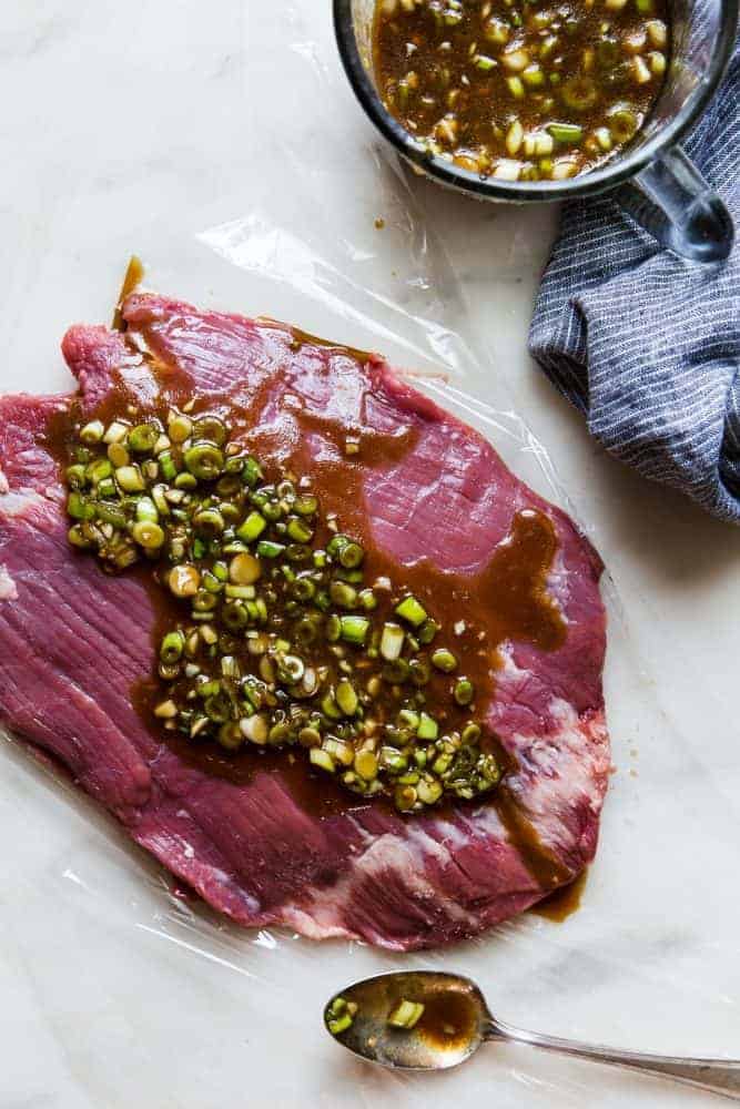 Brown Sugar Garlic Flank Steak is made with the most amazing brown sugar garlic soy marinade. The steak is grilled to perfection and melt in your mouth delicious!ย Brown Sugar Garlic sauce on un-cooked flank steak.