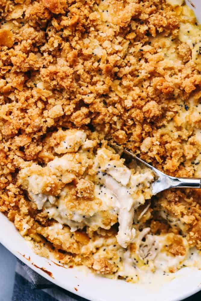 Poppyseed Chicken Casserole is such a classic dish that is incredibly easy to make! A creamy chickenย casserole topped with a buttery ritz topping. This will be the best you ever make!ย Close up of Poppyseed Chicken Casserole in a white platter.