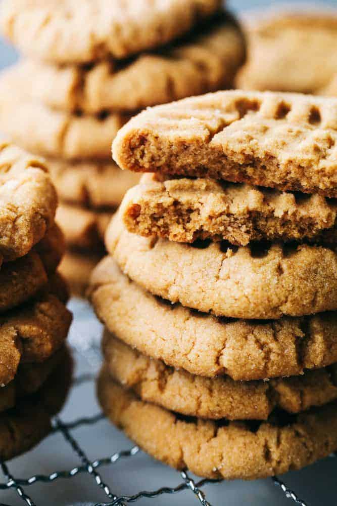Perfectly Soft Peanut Butter Cookies are such a classic recipe! This recipe makes the most perfect and soft peanut butter cookies. This will be the only recipe you ever need! Peanut butter cookies stacked on top of each other on a cooling rack.