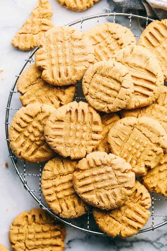 Perfectly Soft Peanut Butter Cookies are such a classic recipe! This recipe makes the most perfect and soft peanut butter cookies. This will be the only recipe you ever need! Several peanut butter cookies stacked on top of each other on a cooling rack.