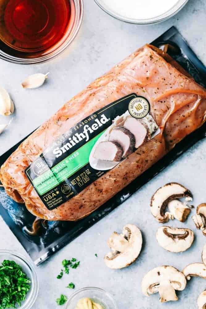 Creamy Garlic Pork Marsalaย is a 30 minute dish that has the most amazing creamy garlic marsala sauce with tender, juicy, fresh pork and mushrooms hidden inside.ย This meal is a unique spin on a traditional chicken marsala dish, and will be on repeat becauseย itsย perfect for busy nights!ย A package of Smithfield Brand Pork with cut mushrooms on the table.