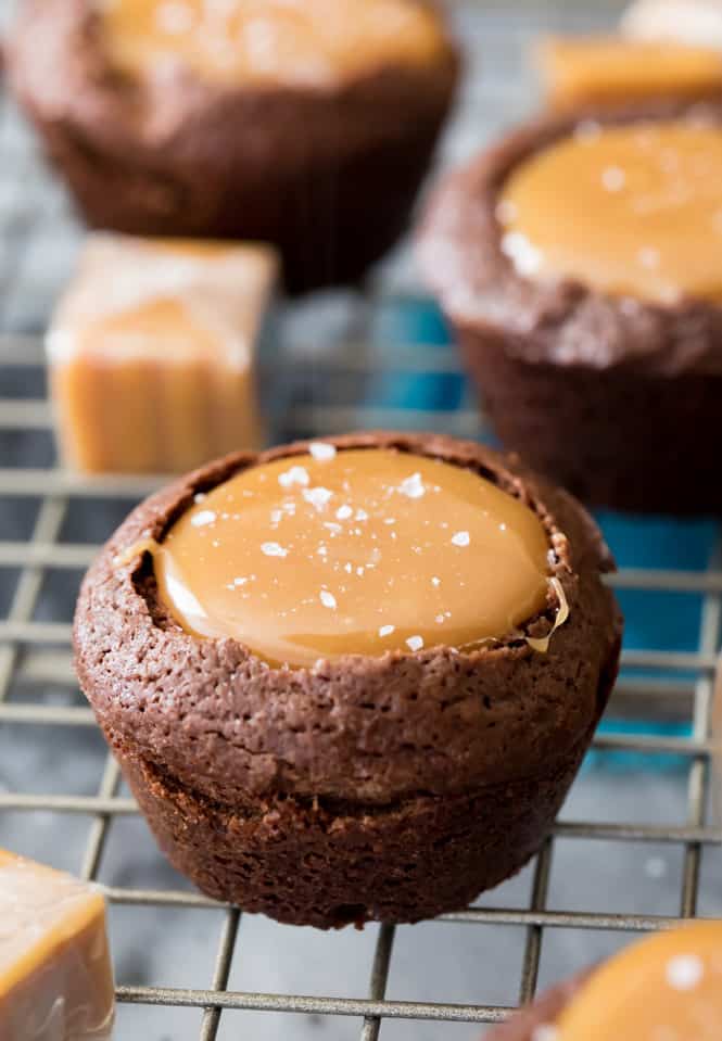 These Salted Caramel Brownie Bites are made with a simple, from-scratch, brownie batter and are filled with a rich (easy to make!) caramel filling! Top everything off with a sprinkle of flaky sea salt for a dessert you'll be coming back to over and over again! Salted Caramel Brownie Bite on a cooling rack.