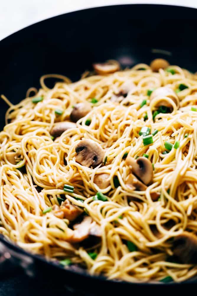 Garlic Mushroom Noodles is an easy side that goes well with grilled chicken, pork chops or asian mains. Silky smooth egg noodles are tossed in a quick sauce with sauteed mushrooms and lots of golden garlic! Closeup of garlic mushroom noodles in a wok.