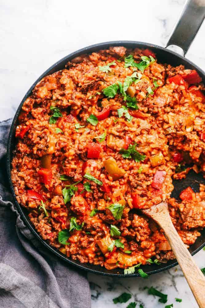 Unstuffed Pepper Skillet has all of the things that you loved about a stuffed pepper in an easy to make skillet meal! This is loaded with ground beef, peppers, tomato sauce, and cheese, and is sure to become a new family favorite! Unstuffed Pepper Skillet in a skillet with a wooden spoon.