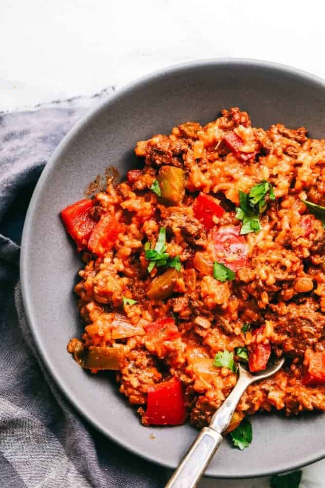 Unstuffed Pepper Skillet has all of the things that you loved about a stuffed pepper in an easy to make skillet meal! This is loaded with ground beef, peppers, tomato sauce, and cheese, and is sure to become a new family favorite! Unstuffed Pepper Skillet in a grey bowl with a metal spoon.