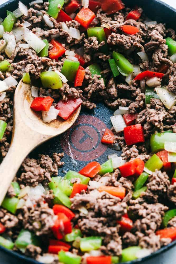 Unstuffed Pepper Skillet has all of the things that you loved about a stuffed pepper in an easy to make skillet meal! This is loaded with ground beef, peppers, tomato sauce, and cheese, and is sure to become a new family favorite! Unstuffed Pepper Skillet in a skillet with a wooden spoon.
