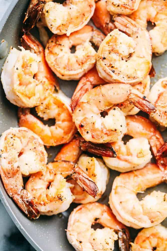 Creamy Garlic Shrimp Alfredo Pastaย is such a classic meal that is brought to its BEST with Shrimp. This meal takes little effort and is so creamy and delicious the entire family will go crazy for!ย Shrimp being cooked in a sauce pan.