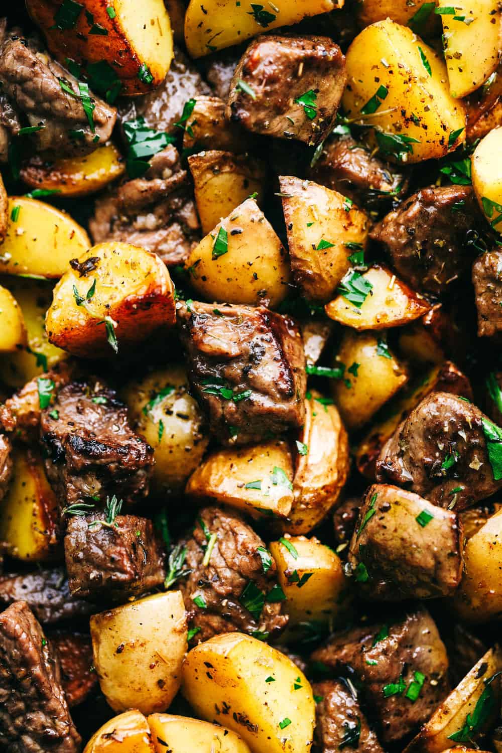 Get ready to obsess! These Garlic Butter Herb Steak Bites with Potatoes are juicy, buttery, and downright irresistible. Easy to make, crazy delicious, and pure comfort in every bite! Close up shot of garlic butter steak bites and potatoes.