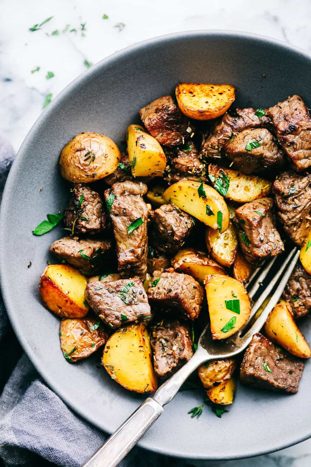 Get ready to obsess! These Garlic Butter Herb Steak Bites with Potatoes are juicy, buttery, and downright irresistible. Easy to make, crazy delicious, and pure comfort in every bite! Plated garlic butter steak bites with potatoes.