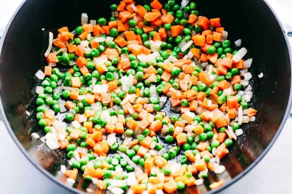 Bacon Fried Rice is 1000x better than takeout and has crispy bacon, eggs, peas, carrots and rice that combine to make the best fried rice ever! Peas and carrot mixture in a frying pan.