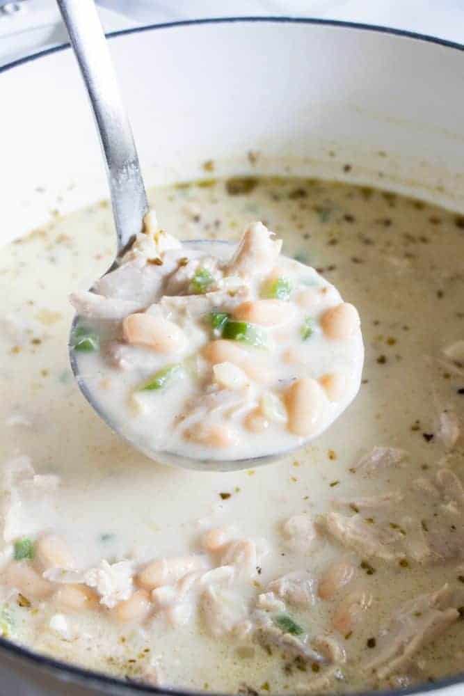 Creamy White Chicken Chili. An easy to make chicken chili recipe that is loaded up with juicy, tender bites of chicken, white beans, green chiles and jalapeno. All in a flavorful, creamy broth. A ladle full of Creamy White Chicken Chili.