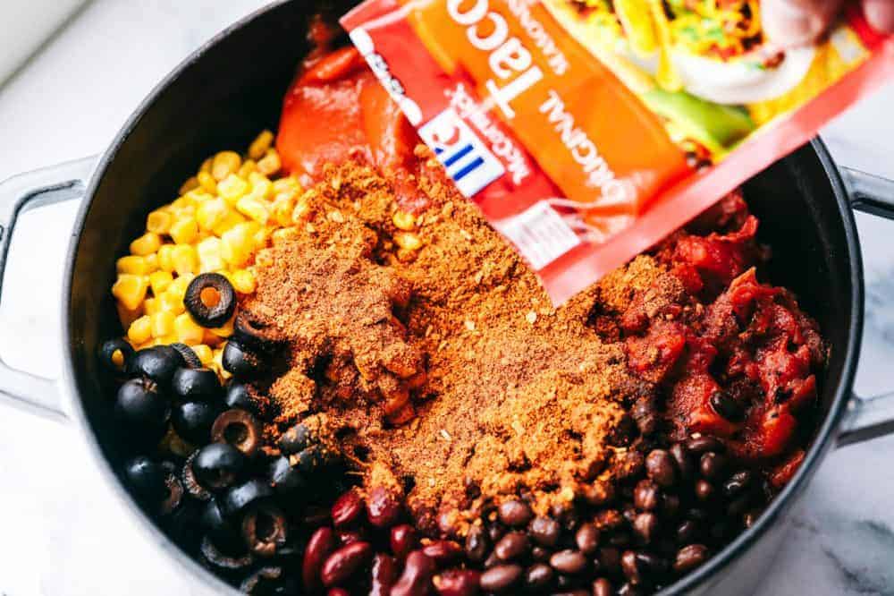 Cheesy Taco Soup is so simple to throw together and is loaded with taco inspired ingredients. The cheesiness takes this soup to the next level of delicious and will be loved by the entire family! All of the ingredients for Cheesy Taco Soup in a large pot.