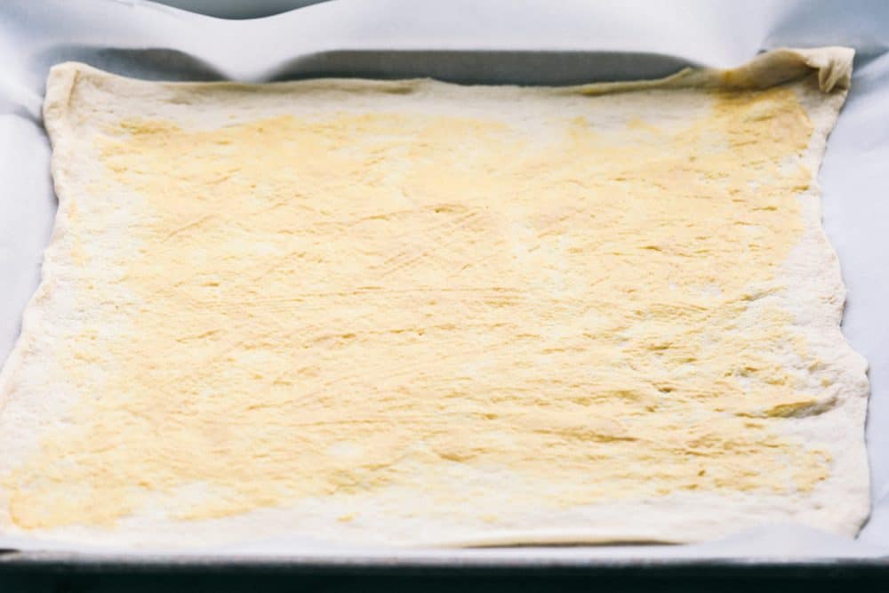 Easy Ham and Swiss Stromboliย can be anything you want it to be! Breakfast? Yes. Brunch? You bet. Dinner? Of course! This meal is a triple threat. It's easy enough to be a side dish. But so good it will be the star of the table.ย Dough rolled out on a sheet.