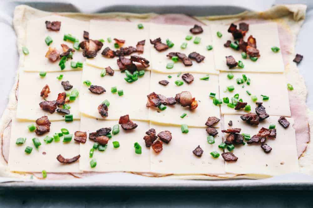 Easy Ham and Swiss Stromboliย can be anything you want it to be! Breakfast? Yes. Brunch? You bet. Dinner? Of course! This meal is a triple threat. It's easy enough to be a side dish. But so good it will be the star of the table.ย Easy Ham and Swiss Stromboli before being rolled up.