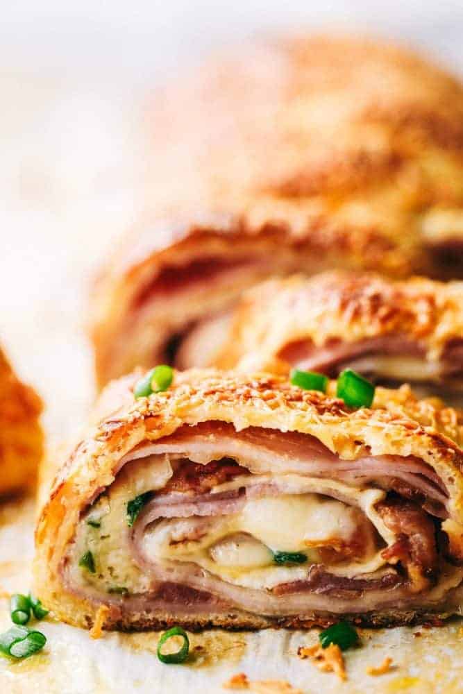Easy Ham and Swiss Stromboliย can be anything you want it to be! Breakfast? Yes. Brunch? You bet. Dinner? Of course! This meal is a triple threat. It's easy enough to be a side dish. But so good it will be the star of the table.ย Close up of Ham and Swiss Stromboli.