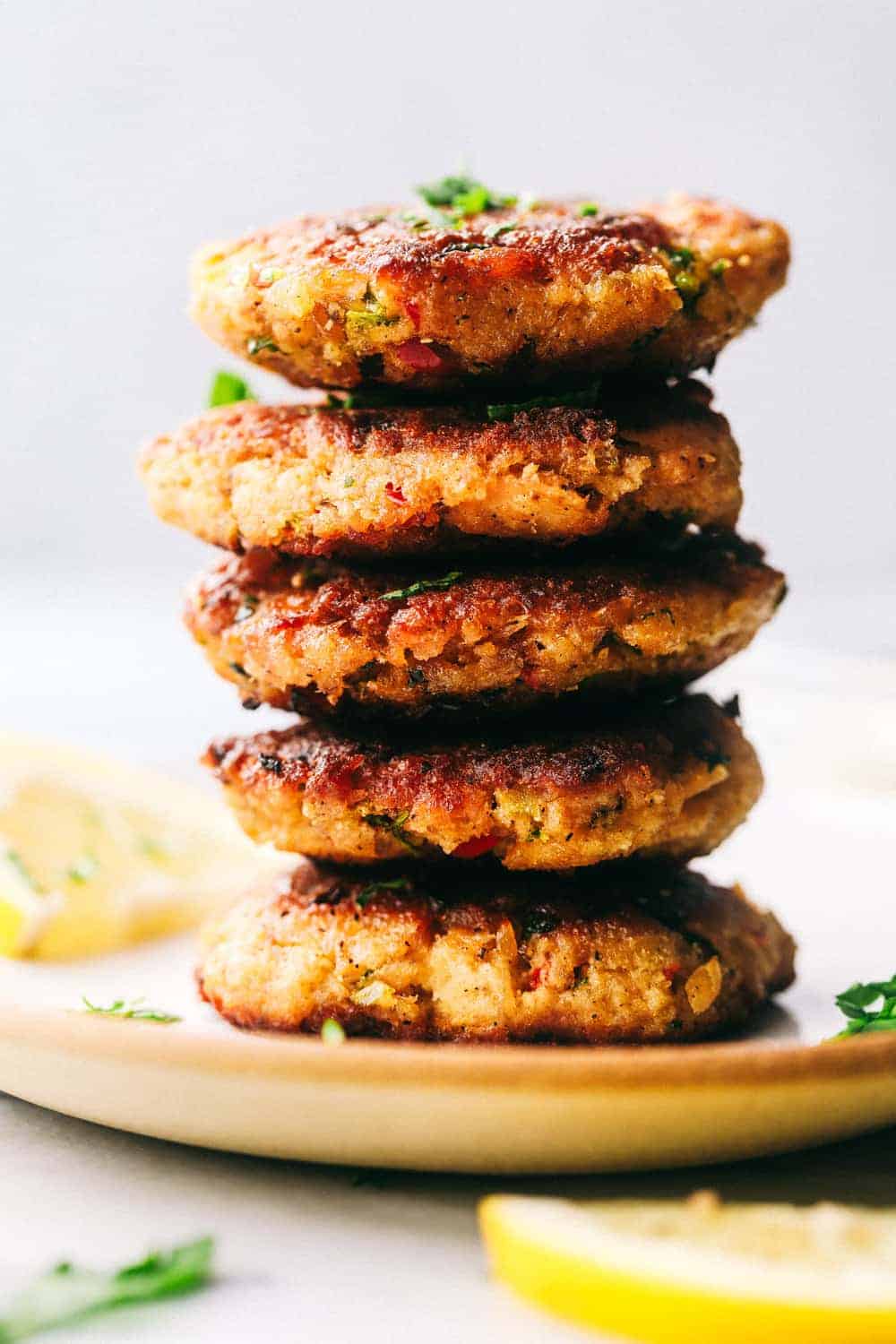 Salmon Croquettes are pan fried and packed with so many great flavors. These make a quick and easy weeknight meal and areย delicious with aย tartarย sauce!ย Salmon croquettes stacked on top of one another.