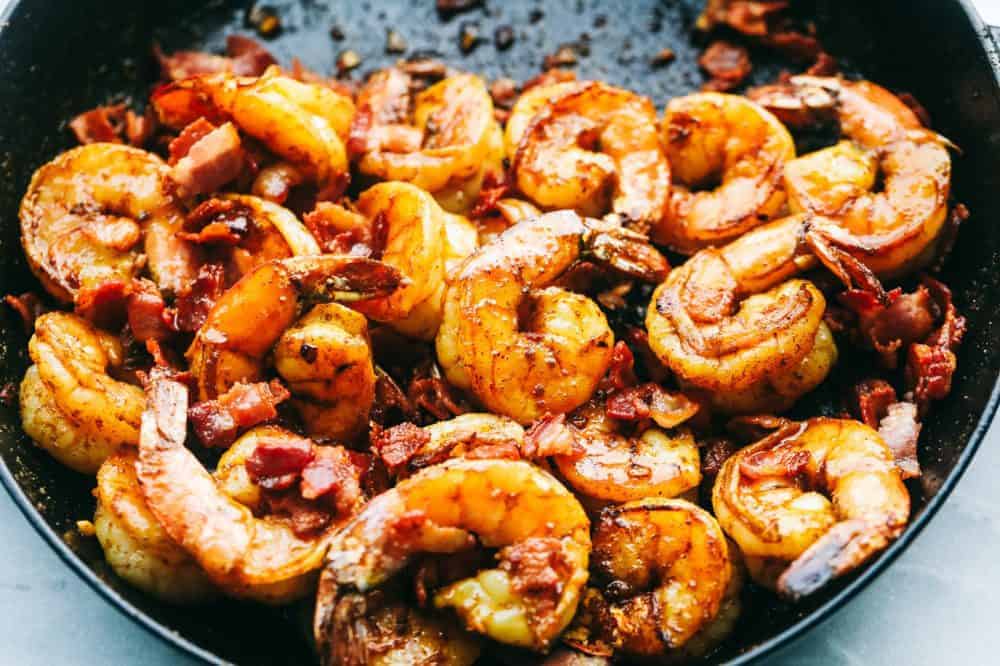 Cajun Garlic Shrimp and Grits are the PERFECT savory dish that you will want on your table. Best part is, it's easy and will make any busy week night delicious. Cajun garlic shrimp in a skillet.