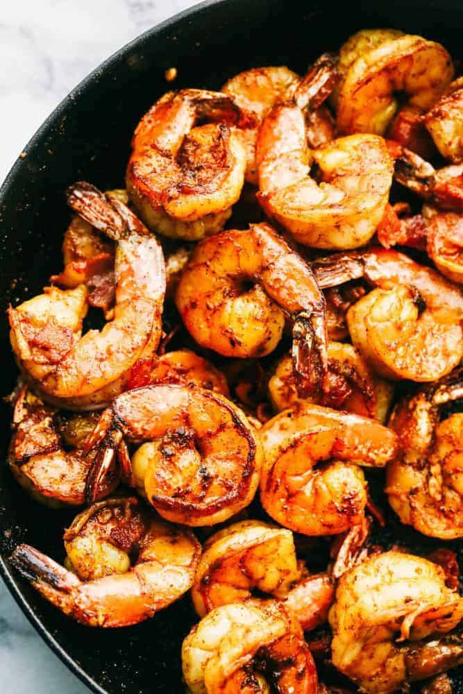 Cajun Garlic Shrimp and Grits are the PERFECT savory dish that you will want on your table. Best part is, it's easy and will make any busy week night delicious. Close-up of Cajun garlic shrimp in a skillet.