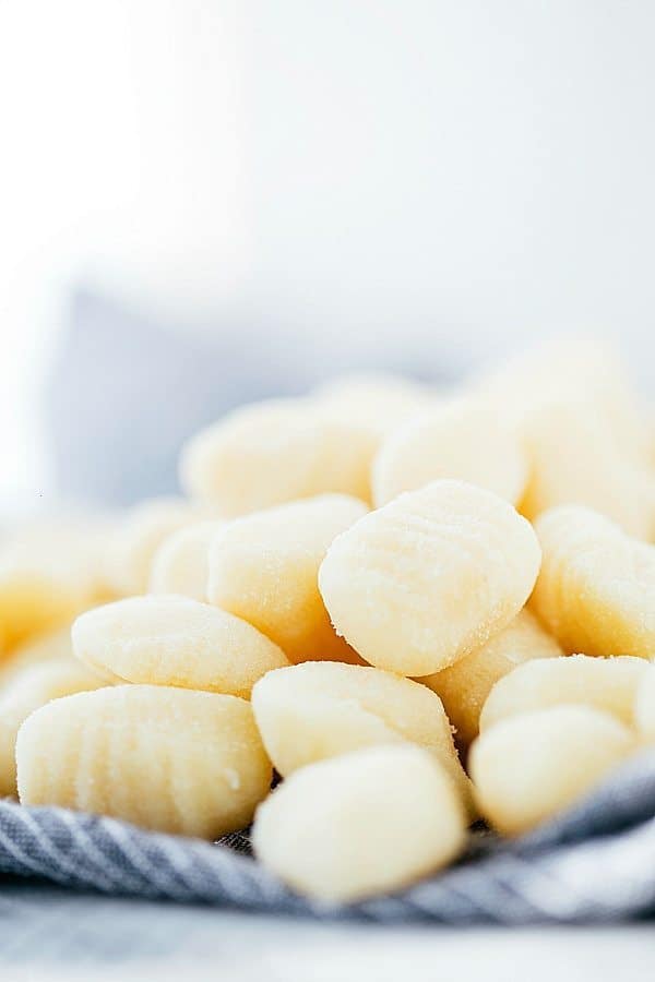 Sausage Tomato Gnocchi is a flavorful tomato sauce with miniature sausage "meatballs" served over gnocchi. A quick and easy meal that the family will all go crazy for!ย A photo with gnocchi stacked on top of each other.