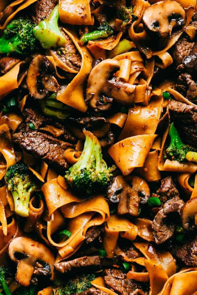 Garlic Beef and Broccoli Noodles is made with tender melt in your mouth beef in the most amazing garlic sauce. Add some mushrooms, broccoli and noodles for an amazing meal in one! Up close photo of Garlic beef and broccoli noodles