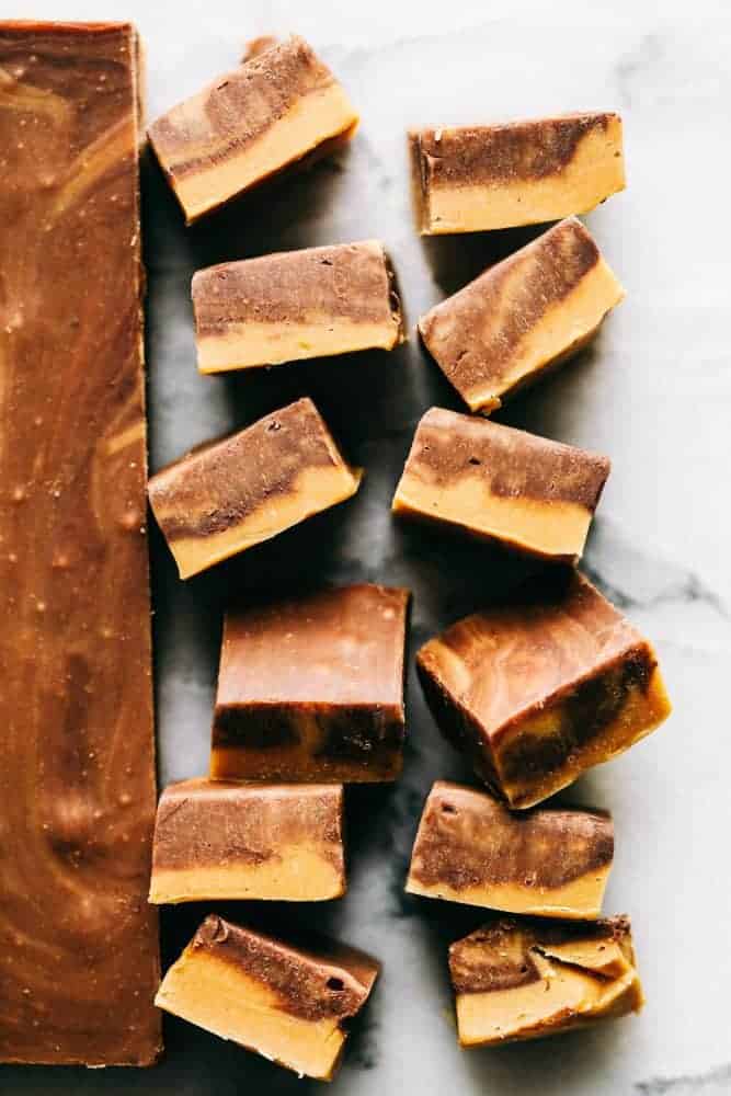 Peanut Butter Chocolate Fudge is an awesome take on the best dynamic duo out there! You cant go wrong with Peanut Butter and Chocolate! Peanut butter chocolate fudge stacked upward showing the different swirls of peanut butter and chocolate fudge.