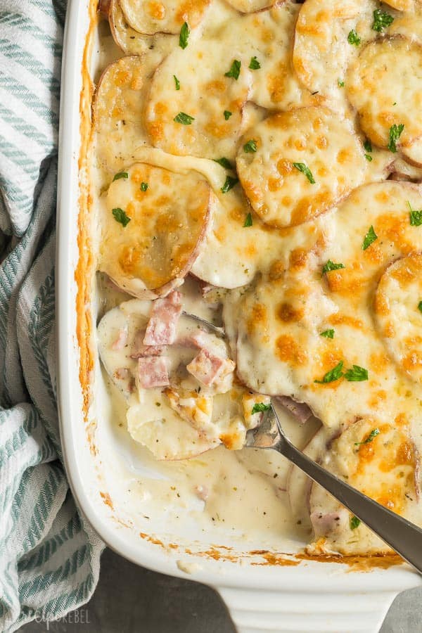 These Scalloped Potatoes and Ham are the perfect make ahead holiday dinner but they're just as good for leftovers, too! Super creamy, cheesy and comforting. scalloped potatoes and ham scoop