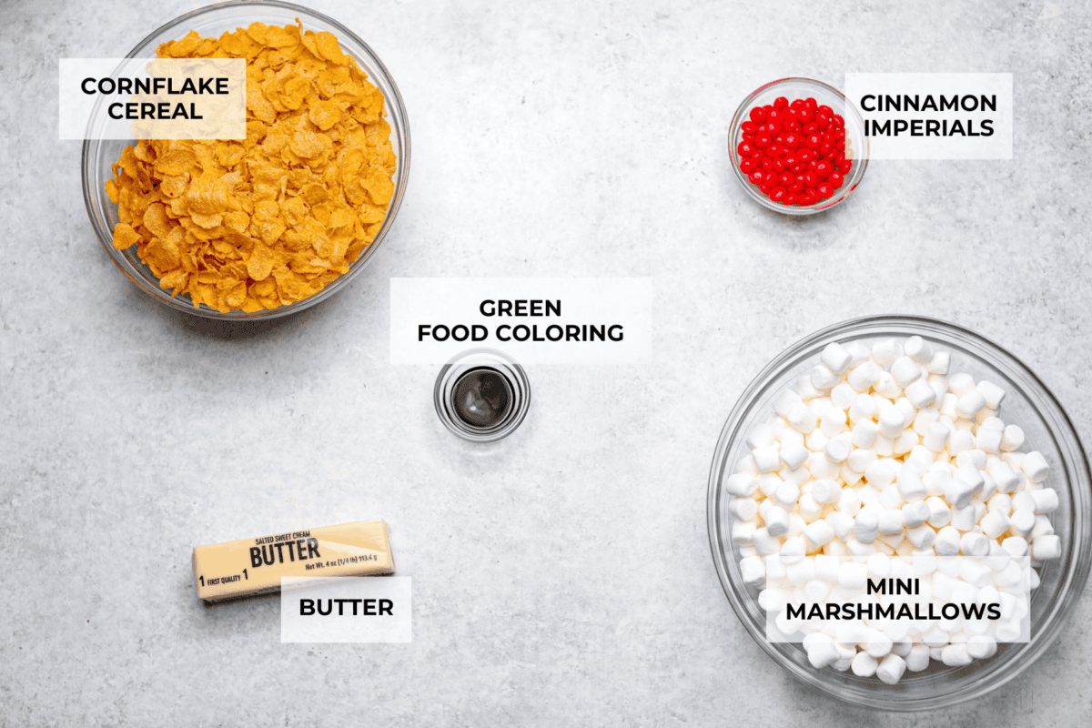 Christmas Cornflake wreaths are a fun, whimsical treat that symbolizes infinite love during the holiday season. Crunchy cornflakes, bright green food coloring, and a sweet, gooey glaze combine to make the cutest Christmas wreath treats. Overhead shot of labeled ingredients for Christmas cornflake wreaths.