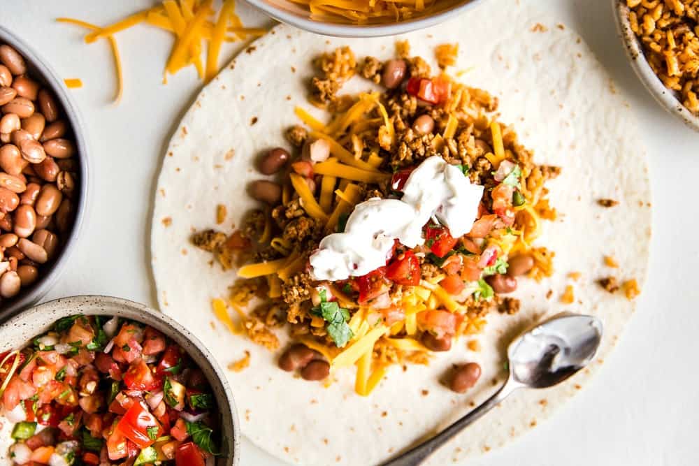 Easyย Mini Burritosย are packed with groundย chicken, pinto beans, Pico deย Gallo and flavorfulย Mexican rice. A classic burrito that is ready to show your tastebuds the next level. These Mini Burritos will leave you wanting more! Building the burrito.