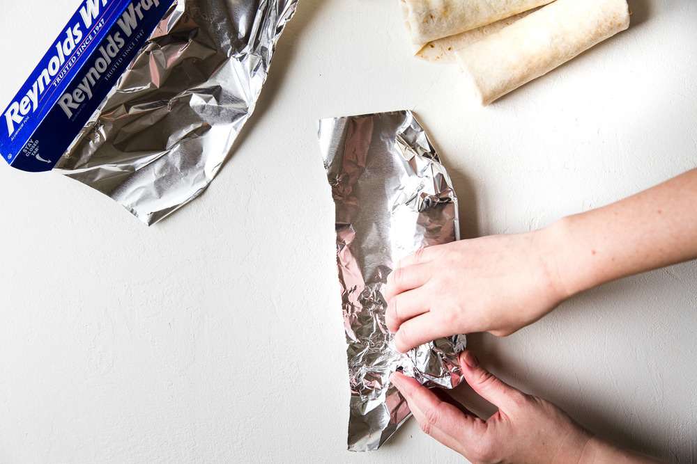 Easyย Mini Burritosย are packed with groundย chicken, pinto beans, Pico deย Gallo and flavorfulย Mexican rice. A classic burrito that is ready to show your tastebuds the next level. These Mini Burritos will leave you wanting more! Tuck in the sides of the aluminum foil as you wrap the burrito.