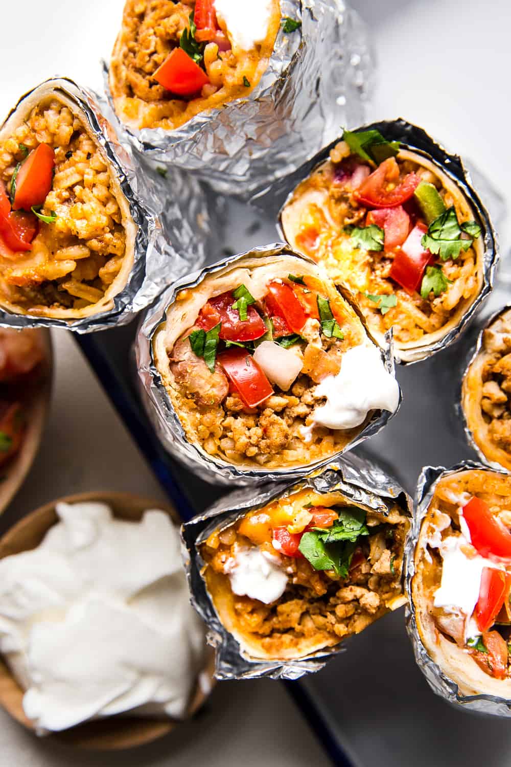Easyย Mini Burritosย are packed with groundย chicken, pinto beans, Pico deย Gallo and flavorfulย Mexican rice. A classic burrito that is ready to show your tastebuds the next level. These Mini Burritos will leave you wanting more! A stack of mini burritos.
