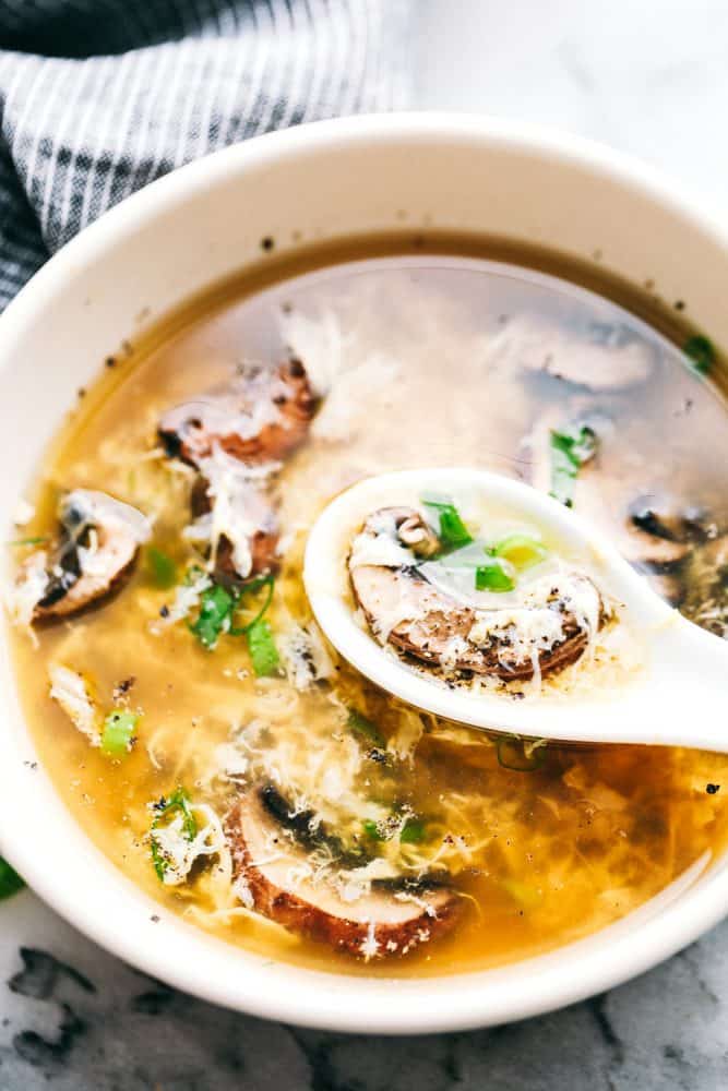 Egg Drop Soupย is a warm,ย thickened broth, with rich flavors of chicken andย beautiful eggย ribbons throughout.ย Enjoy this savory, simple to make soup recipe that comes together in just 15 minutes. Scooping up egg drop soup in a spoon.