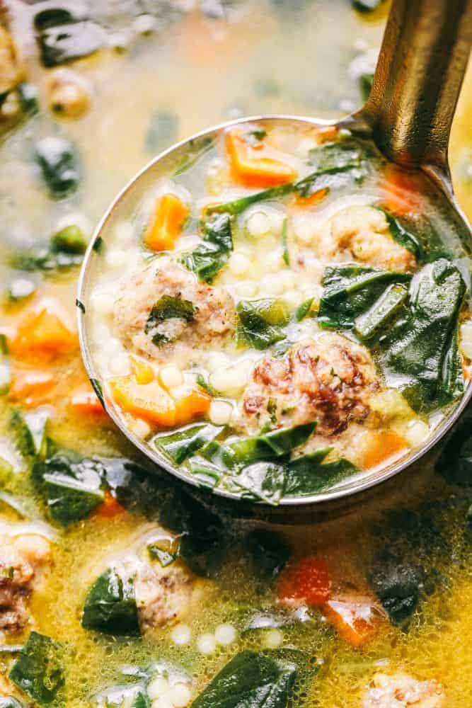 Italian wedding soup is warm and comforting and filled with tender chicken meatballs, veggies, and acini de Pepe. This classic Italian soup will become an instant family favorite! Close up of Italian wedding soup in a bowl with a full ladle.