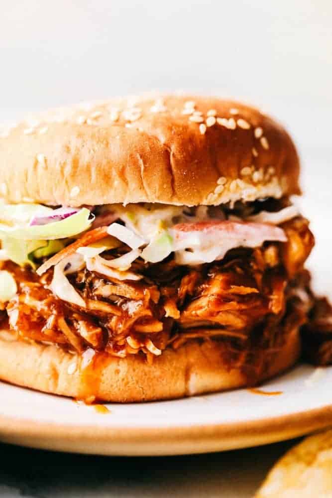 Slow Cooker BBQ Chicken slow cooks to perfection in the best sweet and tangy homemade BBQ sauce. The chicken is so tender and just melts in your mouth with the most amazing flavor! Close up of BBQ chicken sandwich.