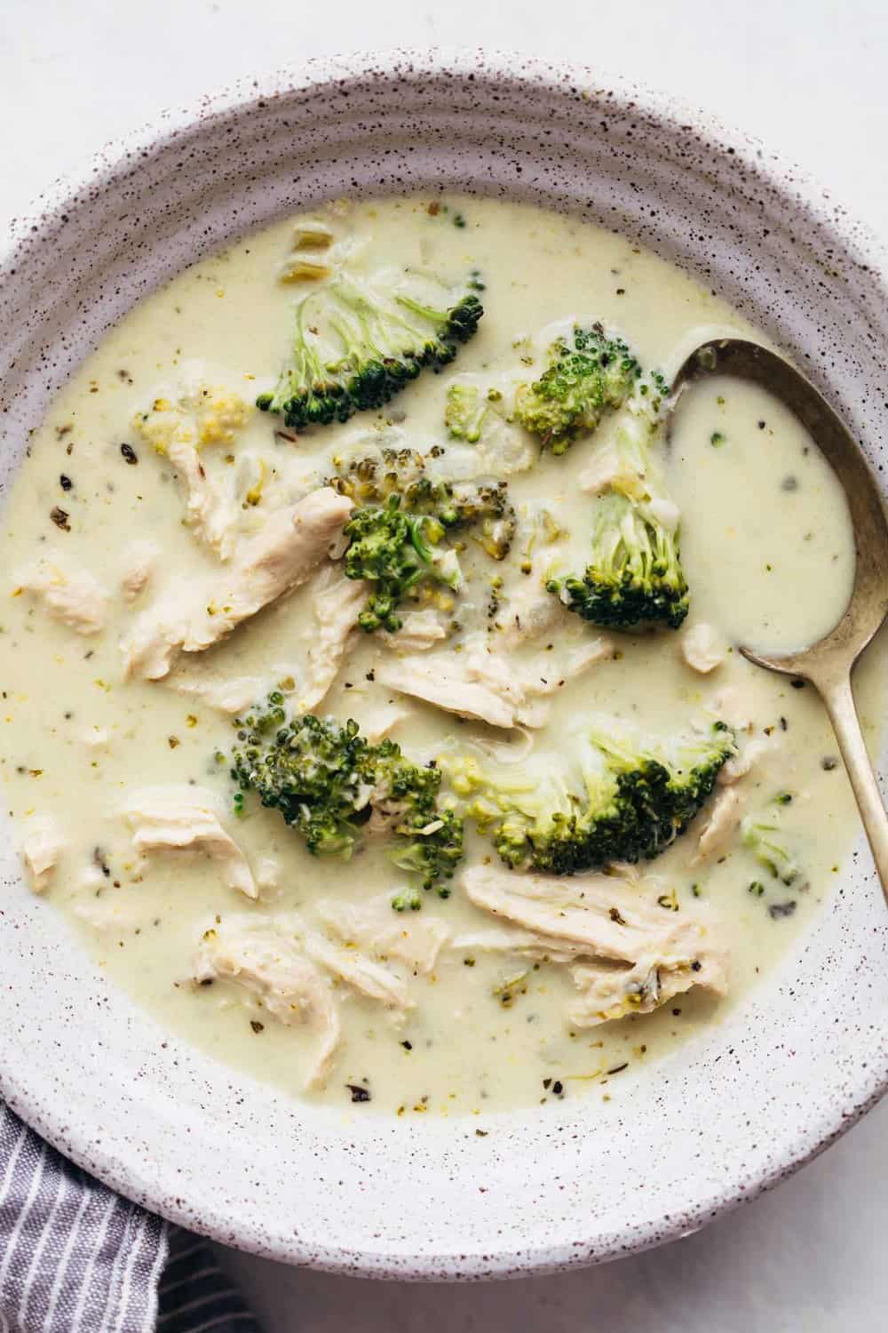Creamy Chicken Broccoli Soup is a hearty soup that's perfect when you want something warm and comforting. Bite sized pieces of broccoli and shredded chicken are simmered in a broth flavoured with onions, celery and dried herbs. It's thick and creamy, and only takes 30 minutes to make. Creamy chicken broccoli soup in a bowl with a spoon