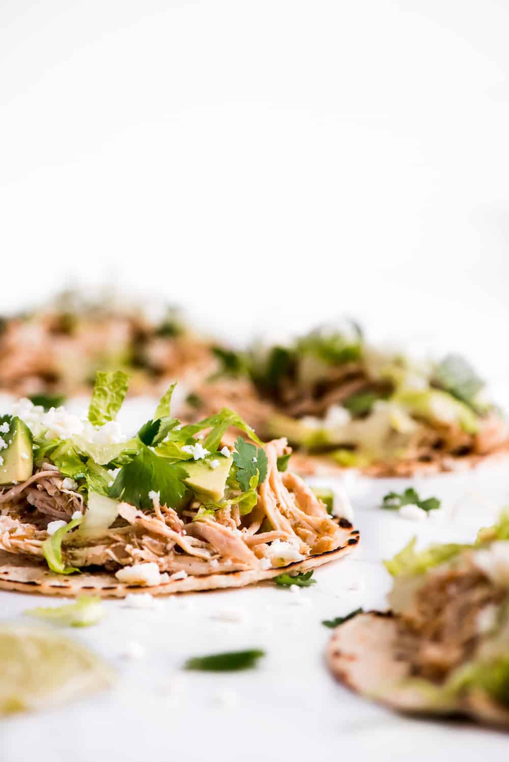 Instant Pot Salsa Verde Chicken Tacos are a family favorite weeknight meal! The flavorful chicken is so quick and easy to make and can be topped with an endless possibility of toppings.ย Instant Pot Salsa Verde Chicken Tacos close up on inside ingredients.
