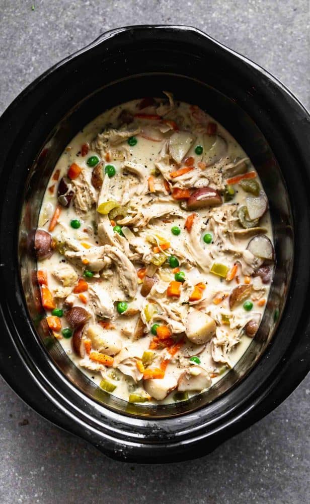 Slow Cooker Chicken Pot Pie is creamy, hearty and addictively delicious. It's packed with tender chicken, crisp veggies, a sauce that will leave you coming back or more, and buttery store-bought biscuits. Perfect for cold and busy winter weeknights! slow cooker chicken pot pie