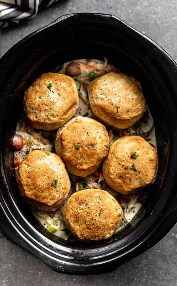 Slow Cooker Chicken Pot Pie is creamy, hearty and addictively delicious. It's packed with tender chicken, crisp veggies, a sauce that will leave you coming back or more, and buttery store-bought biscuits. Perfect for cold and busy winter weeknights! slow cooker chicken pot pie