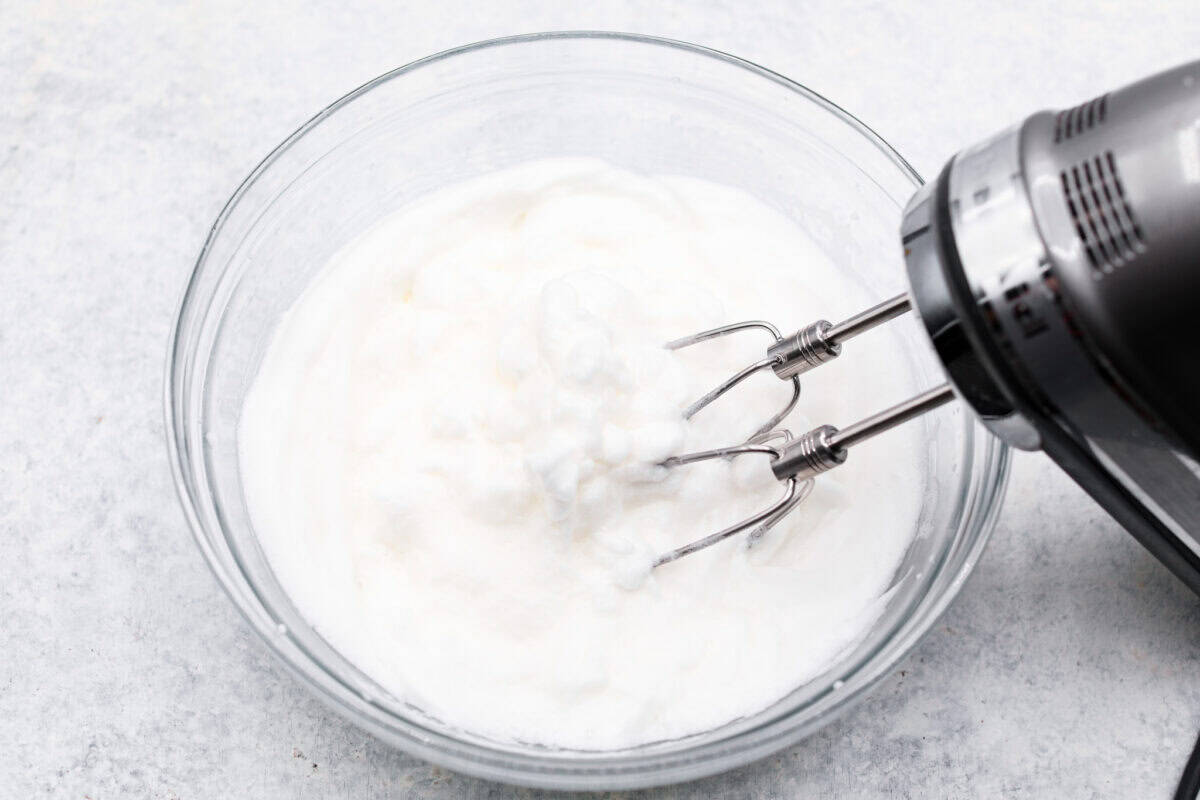 This tender Tres Leches cake is drenched in a three-milk mixture and is topped with fluffy whipped cream, cinnamon, or fresh fruit for a truly authentic Mexican dessert. Overhead shot of egg whites being whipped in a glass bowl with a hand mixer.