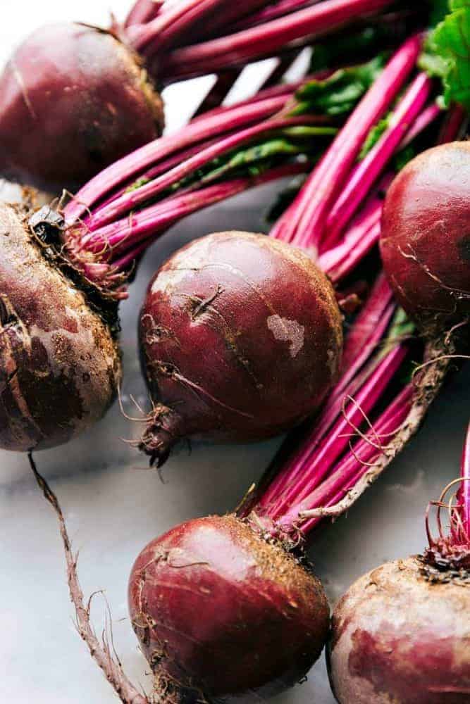 This roasted beet, quinoa, and carrot salad is packed with healthy and good-for-you ingredients! It's super flavorful and has the best lemon dressing! Beets laying on a counter.