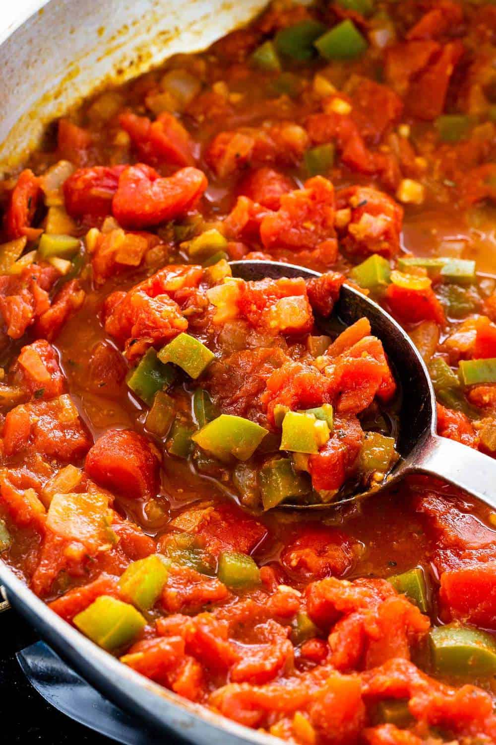 Shrimp Diablo is a fast and fiery Mexican dish for those who love a spicy kick! Succulent shrimp are sauteed with red pepper flakes, jalapenos, garlic, onions, green bell peppers and simmered in a rustic tomato sauce. Ready in just 30 minutes for a bold and flavorful meal. tomato sauce cooking in a skillet